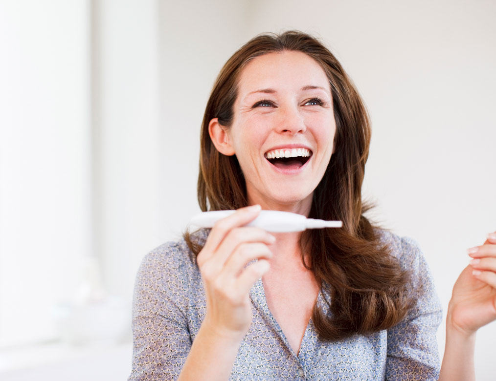 iStock-107429839_1014x780px Frau freut sich über Ergebnis Schwangerschaftstest