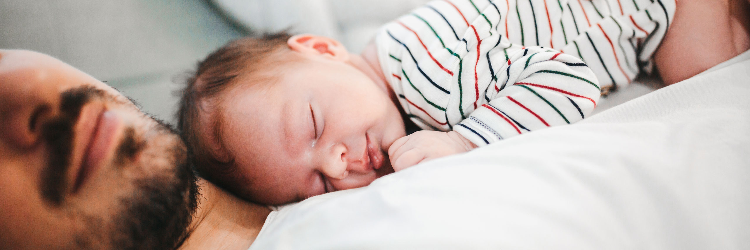 iStock-1296950092_2560x865px Neugeborenes schläft auf Papas Bauch